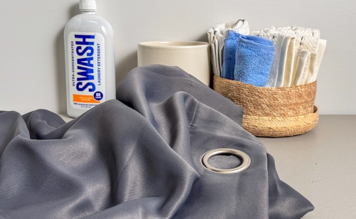 Curtain fabric on a table with cleaning supplies