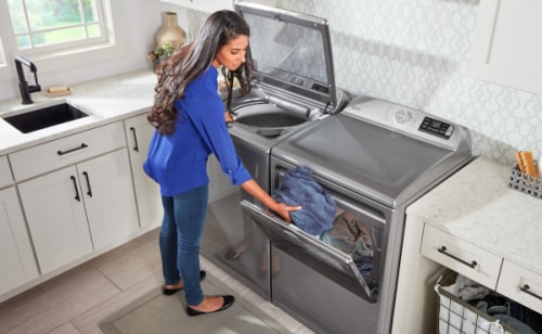 Person at open washer and dryer