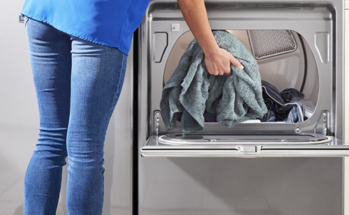 Person putting towels in a dryer