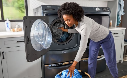 Person loading laundry into a Maytag® washer
