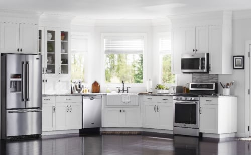 A beautiful, white kitchen with stainless steel appliances