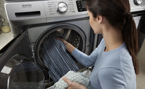 Image of person taking clothing out of a washer