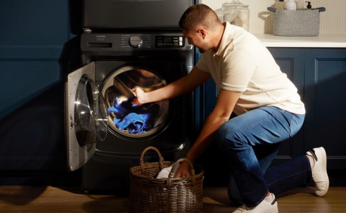 A person taking clothes out of their dryer