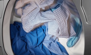 Clothes tumble drying in a Maytag® dryer.