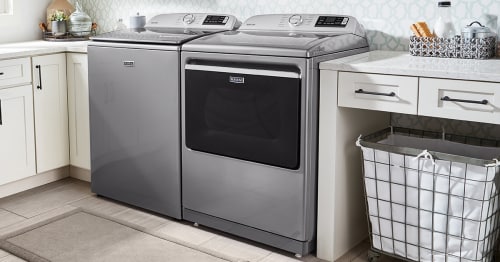 Maytag® top-load washer and dryer pair in white cabinetry