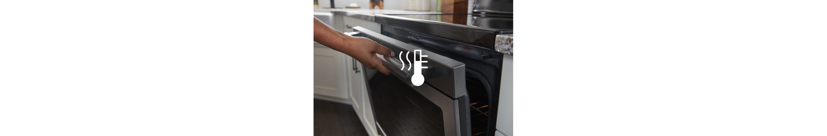 A person wiping down a Maytag® range with a sponge.