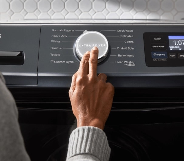 A person pressing the Extra Power button on a Maytag® washer