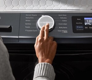 A person pressing the Extra Power button on a Maytag® washer
