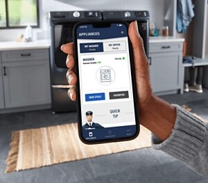 A hand holding a phone with the Maytag Smart Appliance app open