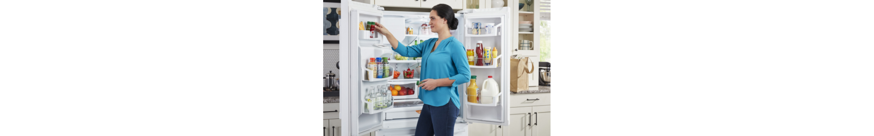 A person putting an item in the door of a Maytag® refrigerator