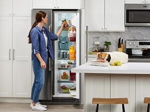 Person placing a jar in a side-by-side refrigerator 