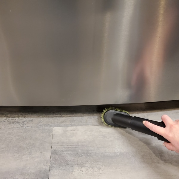 A vacuum brush head cleaning condenser coils.