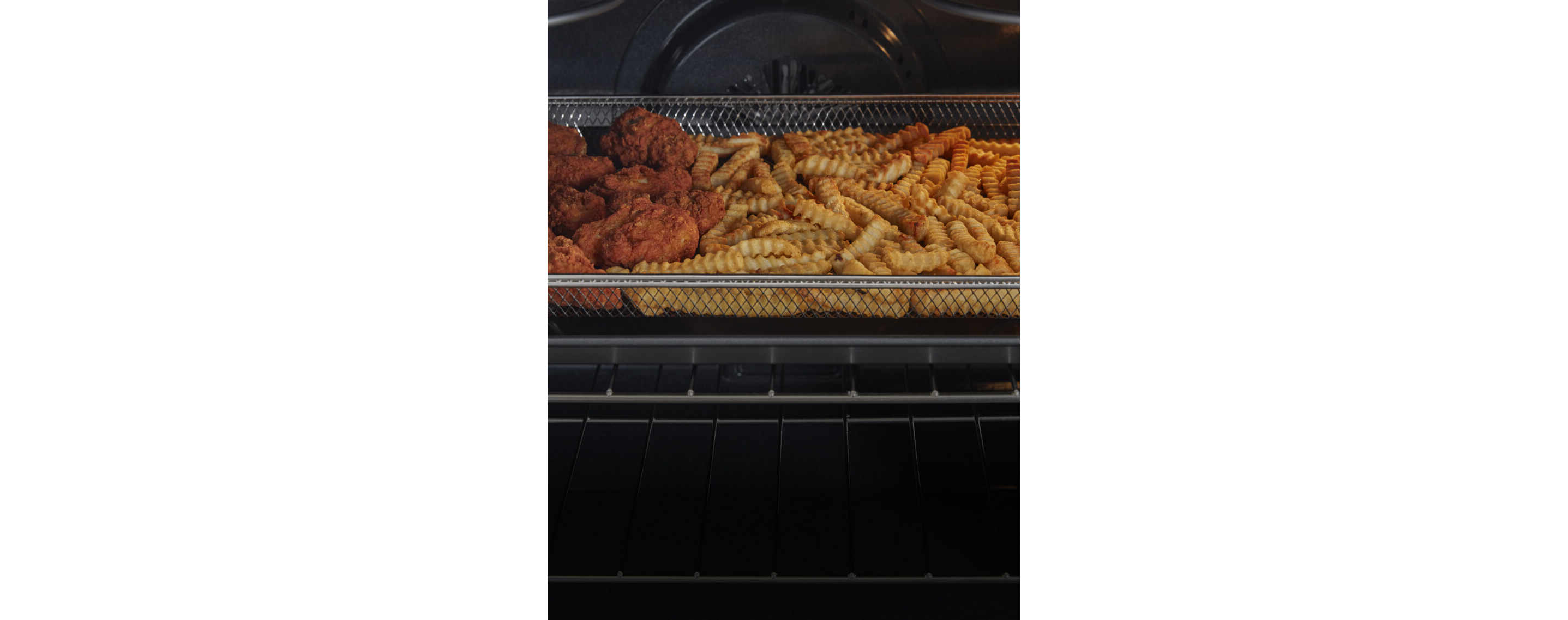 Chicken wings frying in the air fry basket.