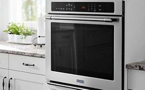 Built-in wall oven in white kitchen.