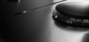 Close up of a gas burner with a black burner cap.