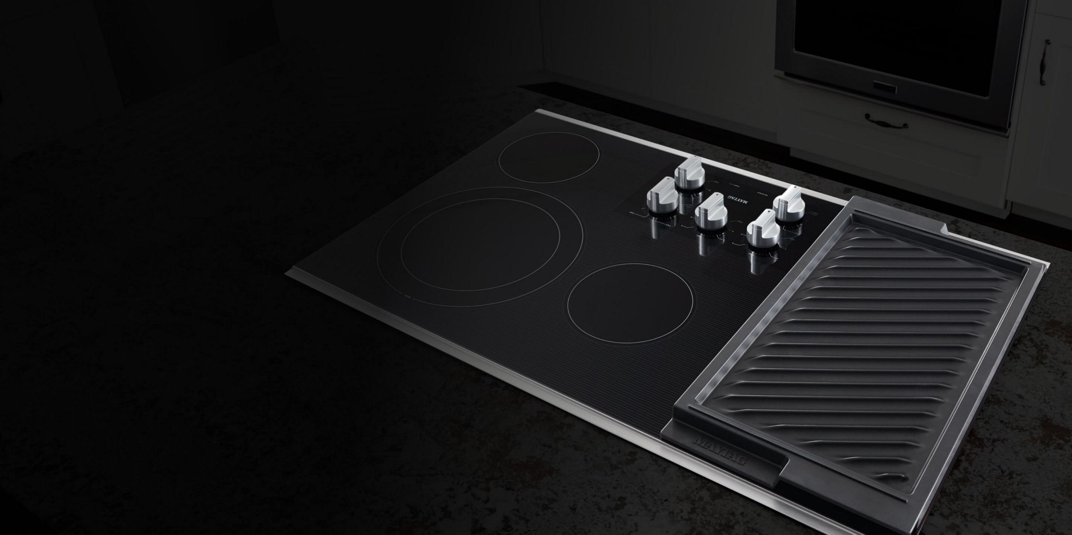 An electric cooktop against a dark background.