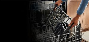 A person adding a cooktop grate to the dishwasher's lower rack.