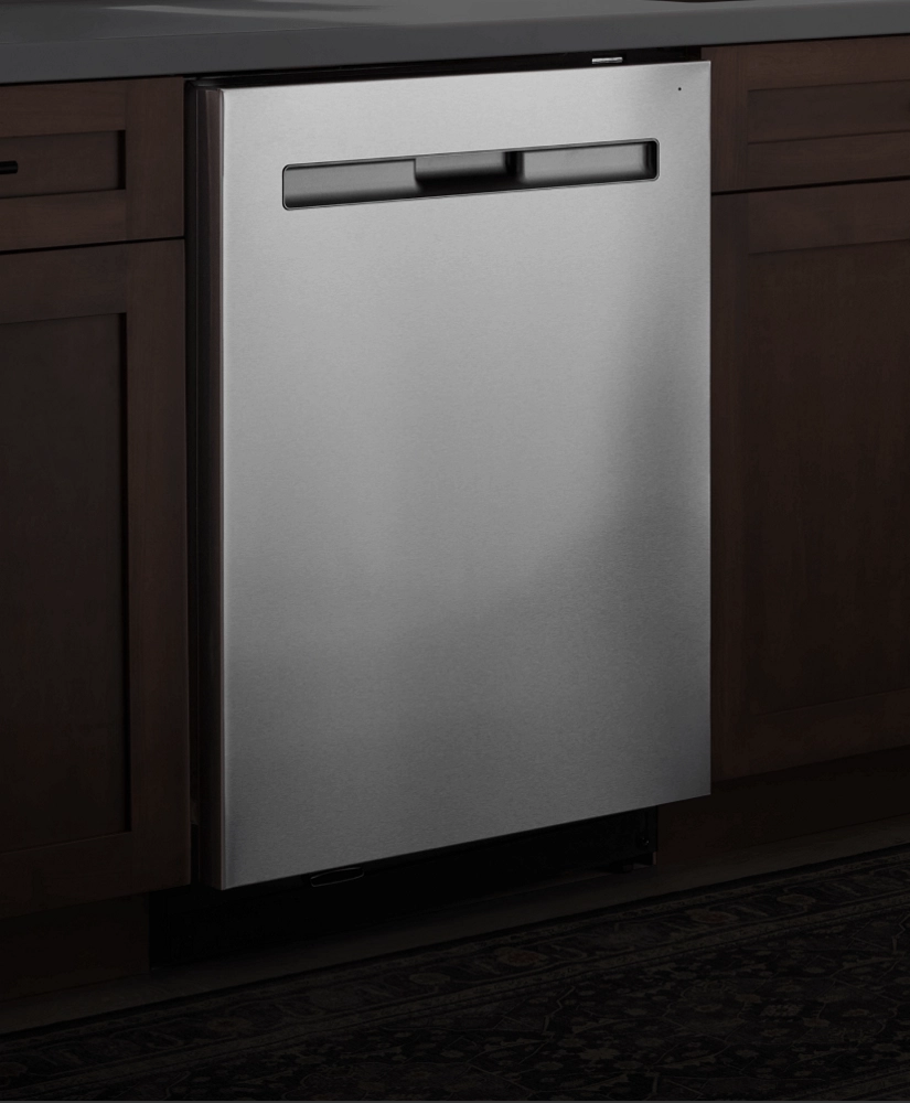 A stainless steel dishwasher against a dark background.