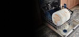 A person adding a cooktop grate to the dishwasher's lower rack.