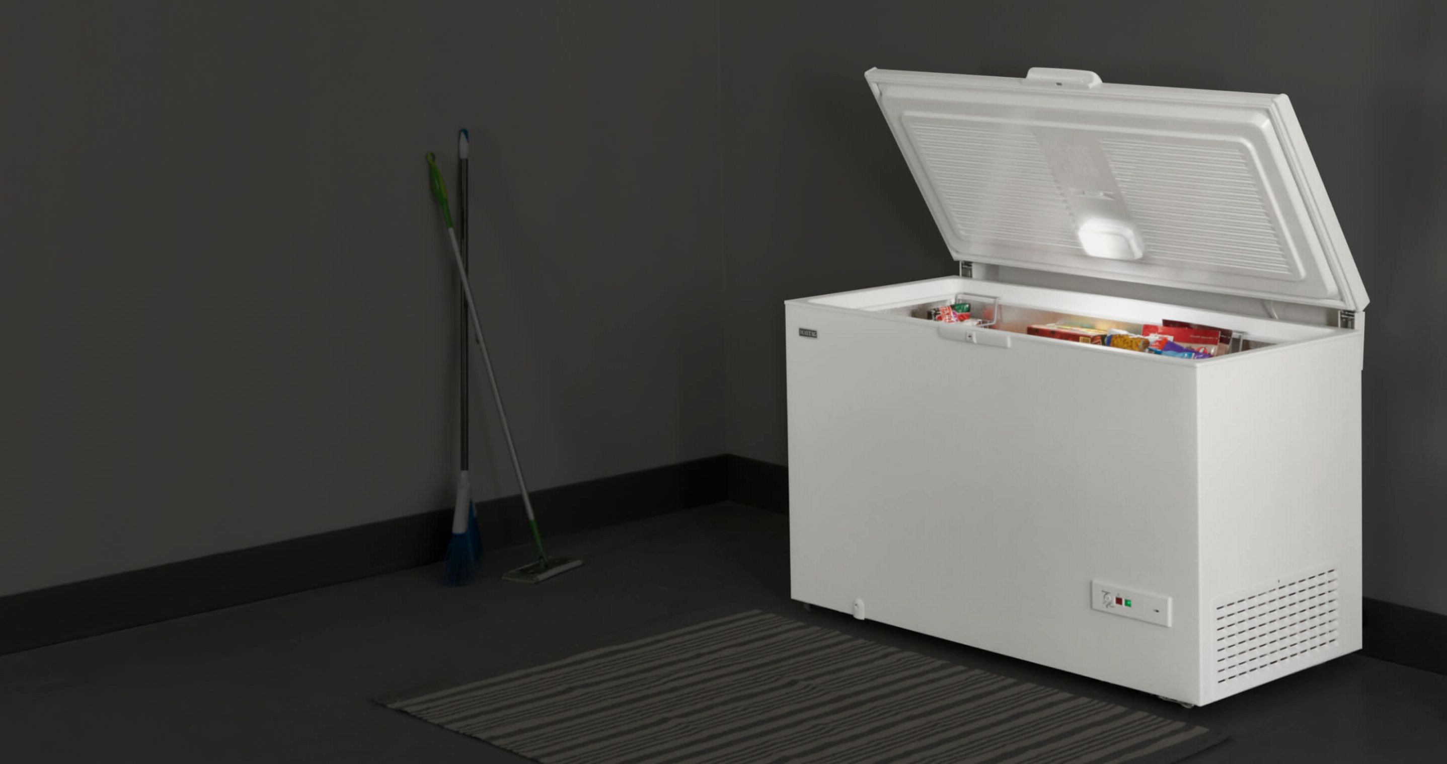 An open Maytag® chest freezer in a garage.