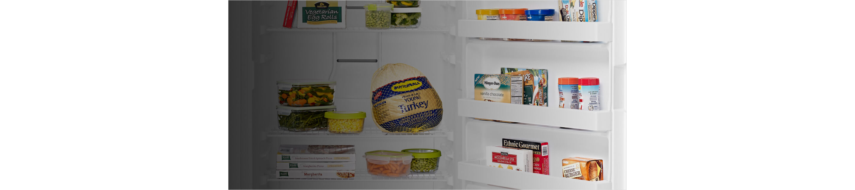A frozen turkey and other frozen food inside a Maytag® upright freezer.