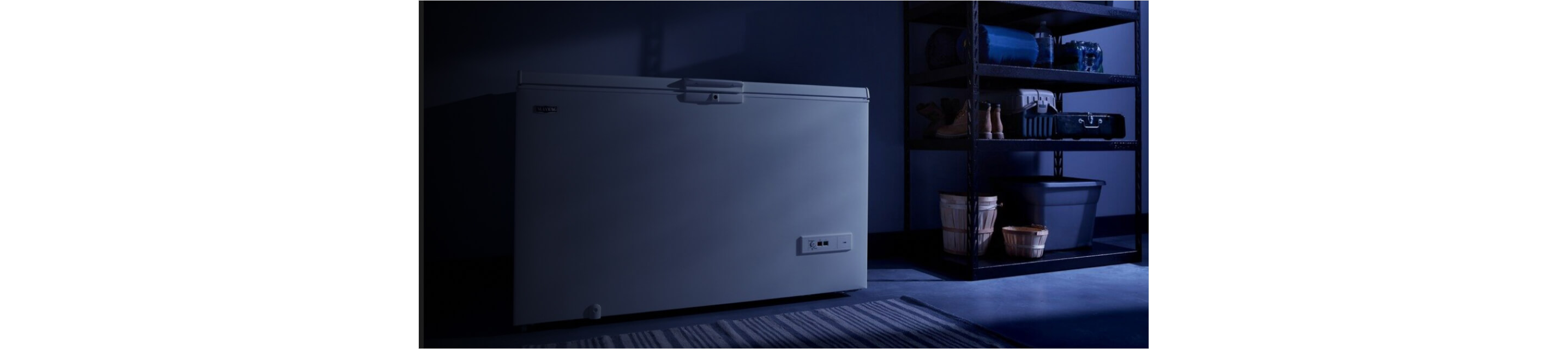 A Maytag® chest freezer in a darkened garage.