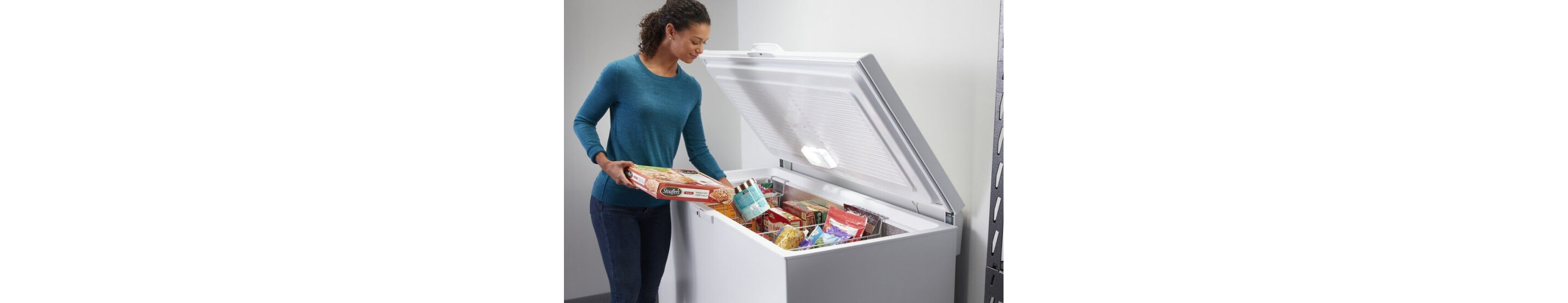 A woman putting frozen food into a Maytag® chest freezer.