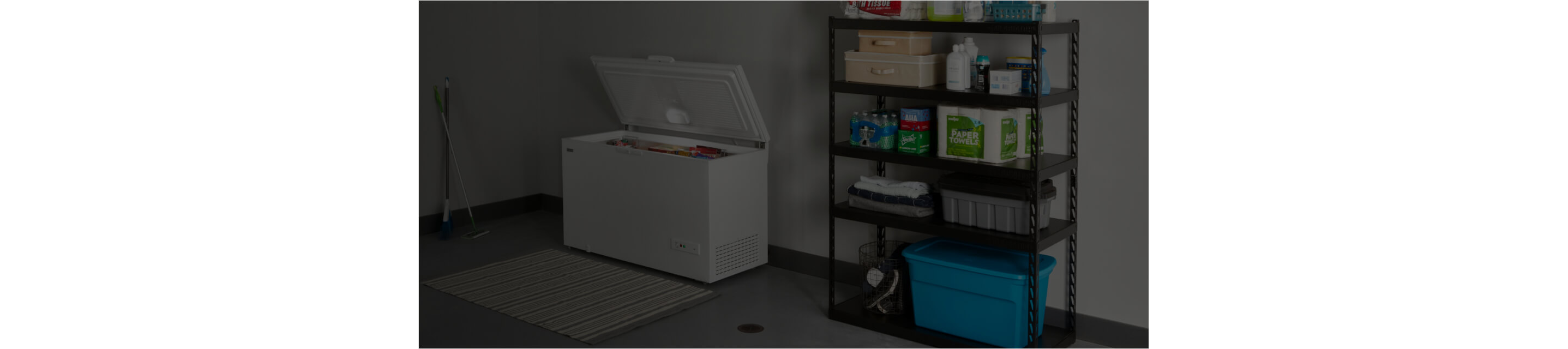 An open Maytag® chest freezer in a garage.