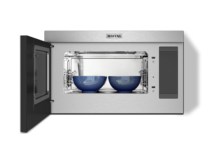 An open microwave with two bowls inside.