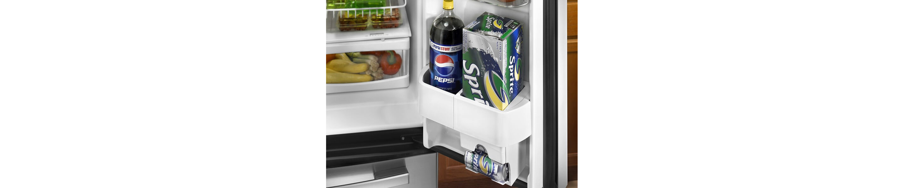 Bottled and canned sodas inside a refrigerator door