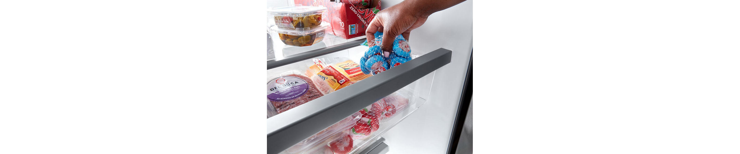 Person placing snacking cheese inside a refrigerator drawer