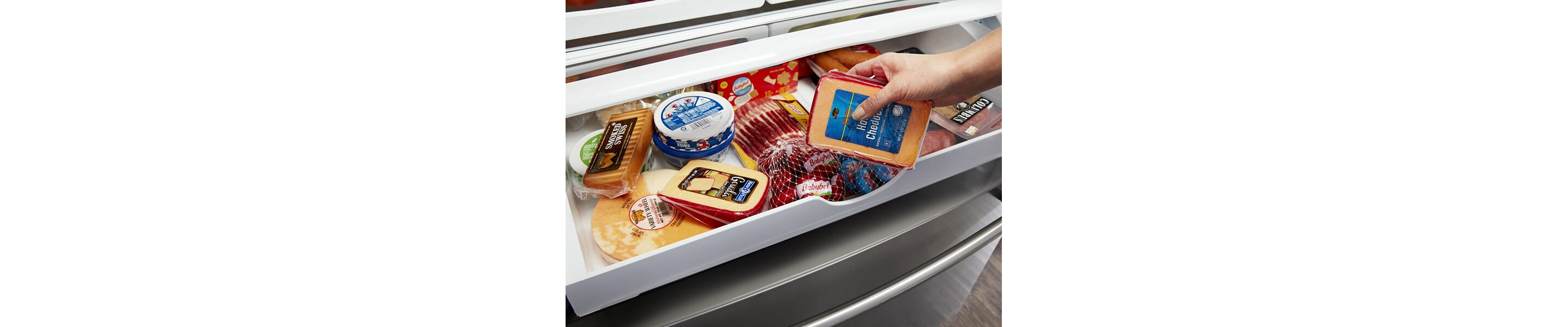 Person placing cheese inside a refrigerator drawer