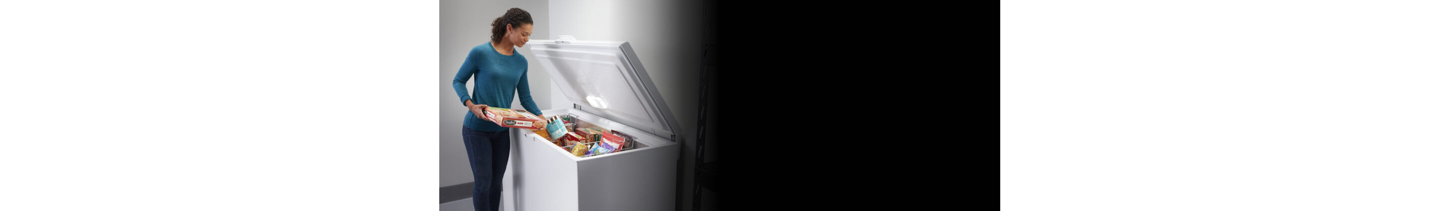 Person loading food into a chest freezer