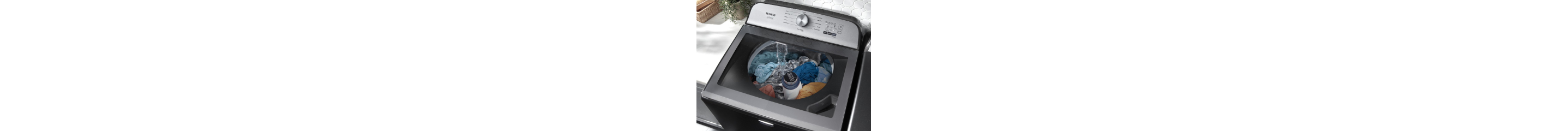 Top view of a washing machine showing water pouring over clothing