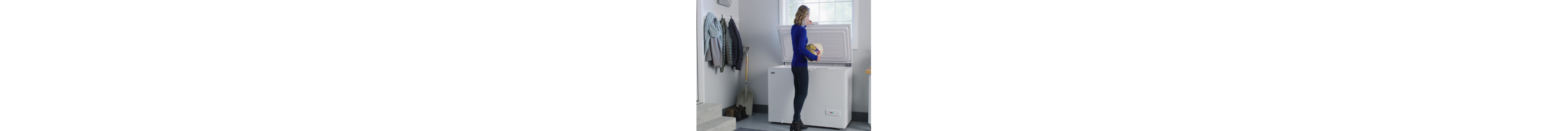 A person taking a turkey out of a chest freezer