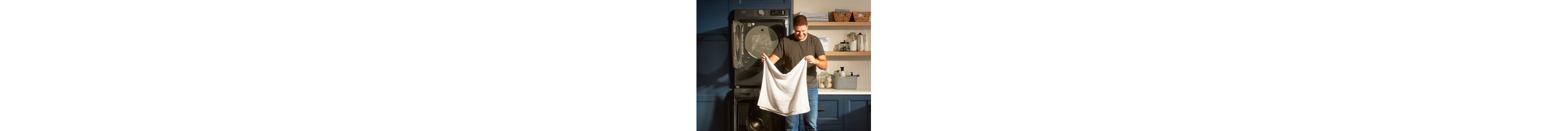 A person holding a towel in front of Maytag® laundry pair