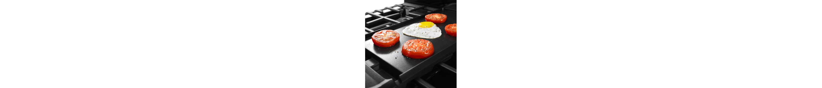 An egg and four tomatoes on a griddle