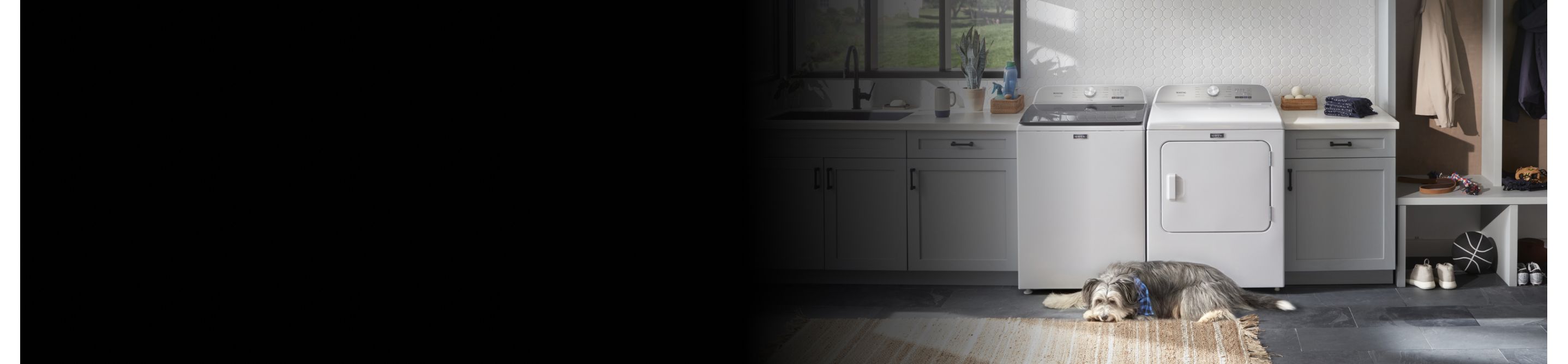 A Maytag® washer with a dog next to it.