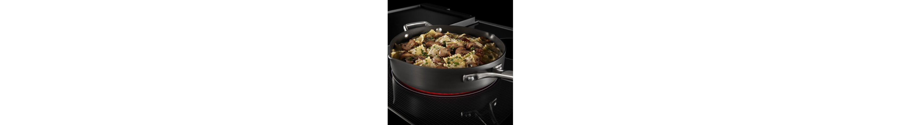 A close-up of a pan of pasta cooking on a Maytag® cooktop