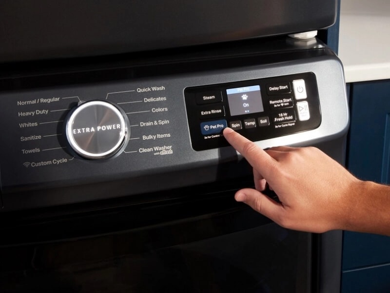 A person touching the control pad on their Maytag® washer