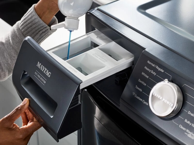 A person putting detergent into their Maytag® washer