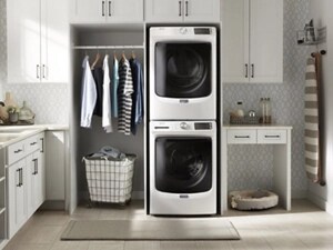 Clothes hanging next to a Maytag® stacked front load laundry pair
