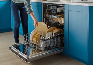 Person loading dishes inside a dishwasher