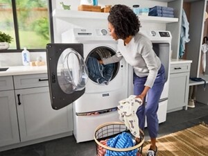 A person putting laundry into a Maytag® Pet Pro Washer
