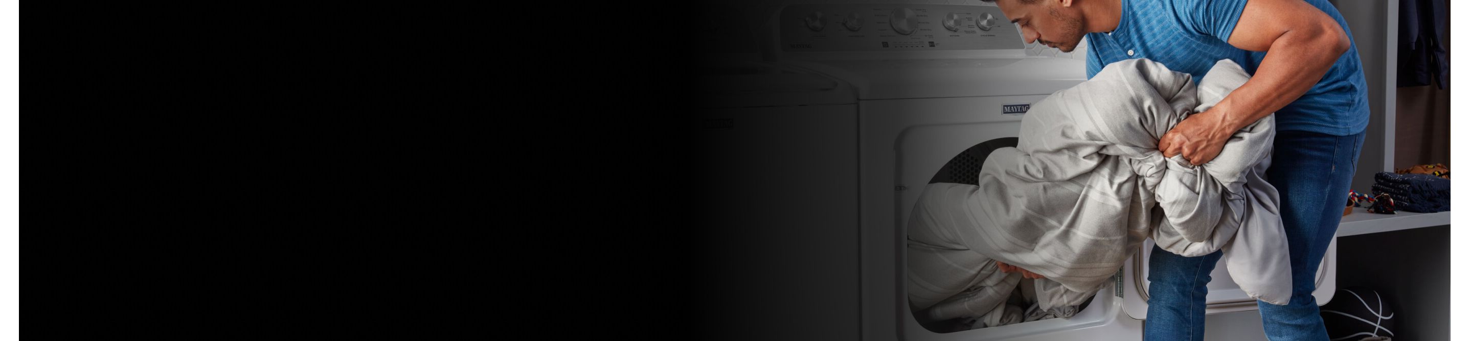 A person loading a comforter into a Maytag® front-load dryer