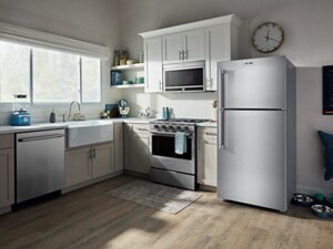 A top-freezer fridge in a cozy kitchen with muted light