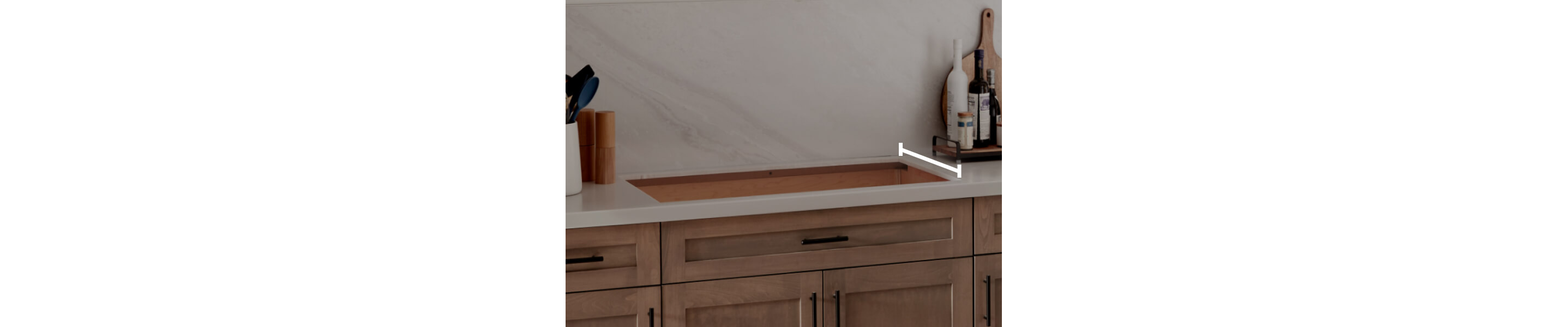 A cooktop cutout within countertops with a line measuring the depth of the cutout
