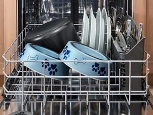 Blue dog bowls, plates and silverware in a dishwasher