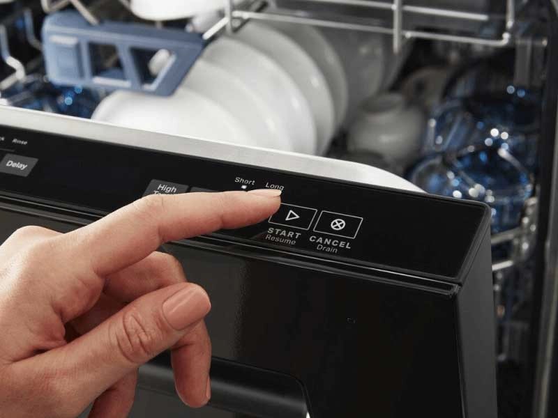 Person selecting dishwasher cycle on a top control dishwasher panel