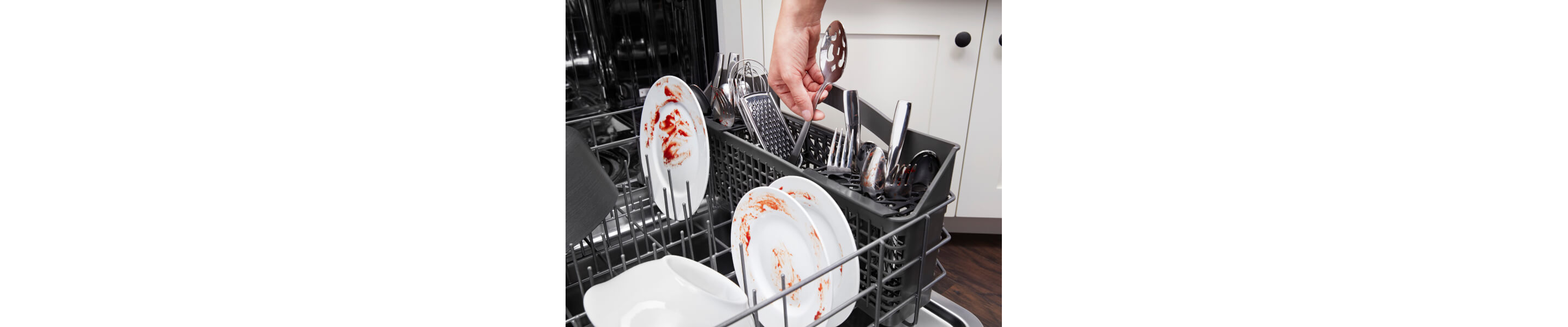 Person placing dirty dishes in a dishwasher